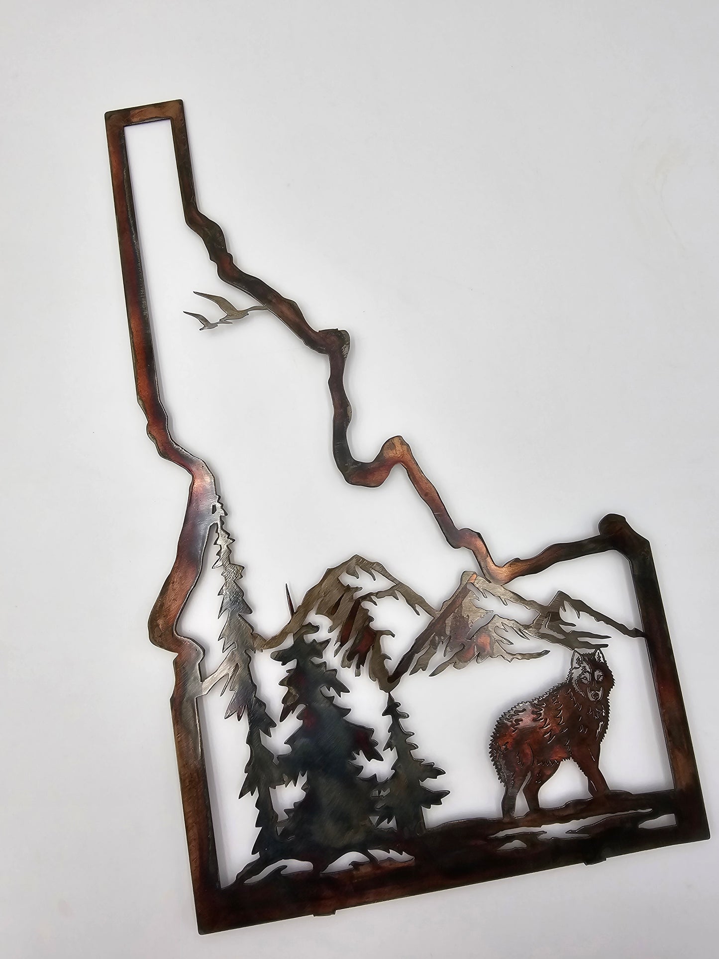 Idaho State Sign with Wolf Mountain Scene. Measures 205 Inches High x 12 Inches Wide x 18 Gauge. Comes in five colors, Colored-Rustic, Flat Black, Hammered Black, Hammered Beige, and Bare Metal. Tabs on back for easy hanging. Comes with other animals as well.