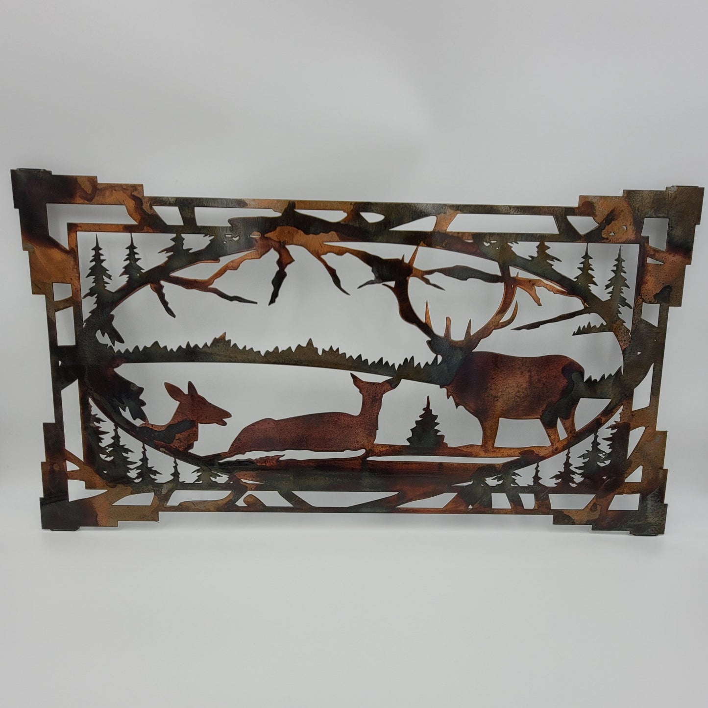 Southwest Oval Elk Wall Hanging. Aztec border frame with and oval center which has mountain, elk and tree scene in the frame. Medium measures 11"H x 20" W x 18 Gauge. Large measures 16" H x 30" W x 18 Gauge. Available in four colors; Colored-Rustic, Black, Hammer Tone, Bare Metal. Sprayed with a layer of Varathane. Gift Wrapping available at check out.