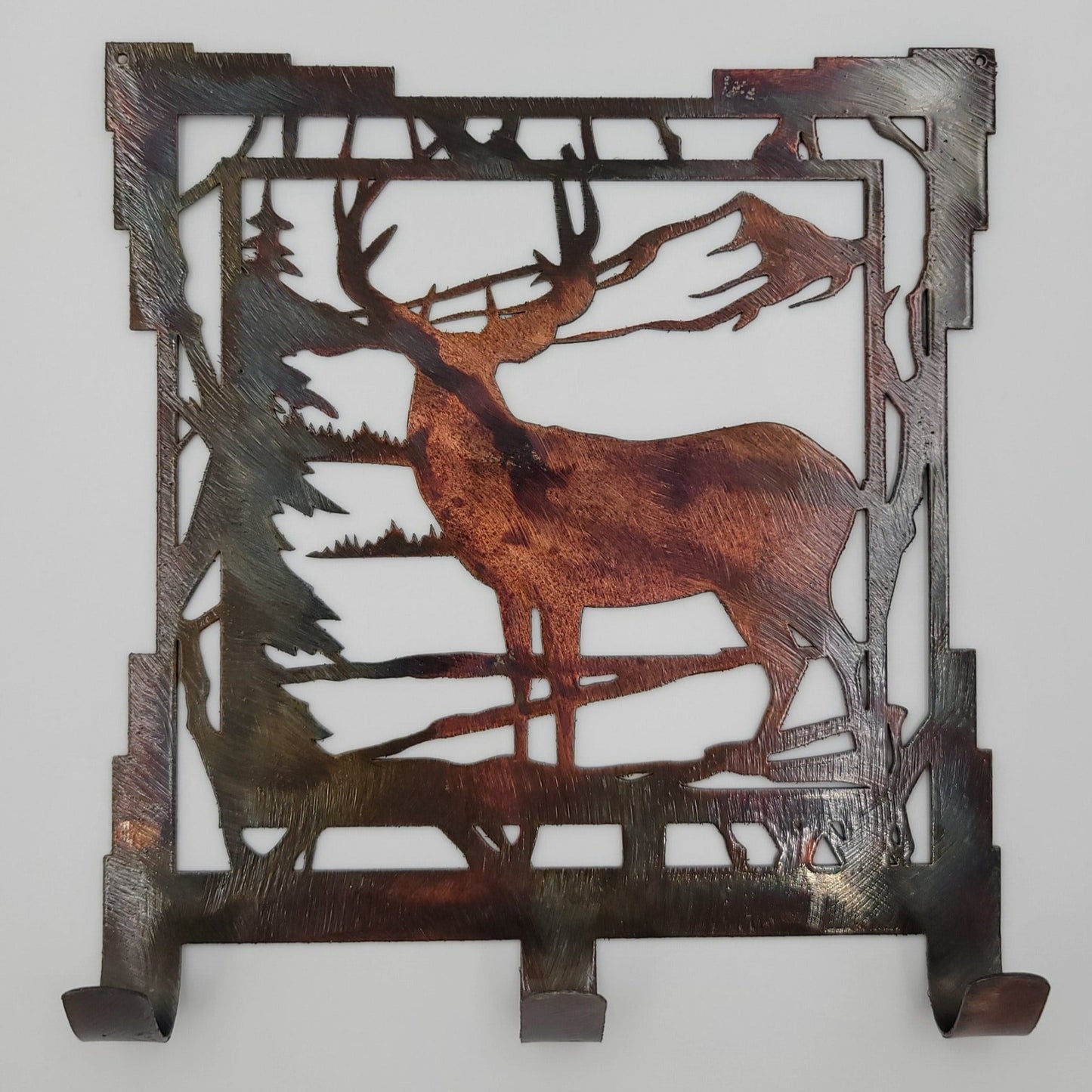 This Southwest Rustic Metal Deer Scene Key Rack is 6.25" wide x 7" high with an 18-gauge thickness. Three hooks allow for easy storage of keys, while two holes in the top corners enable easy hanging with two nails (not included). Available in four colors Colored=Rustic, Black, Hammer Tone, Bare Metal