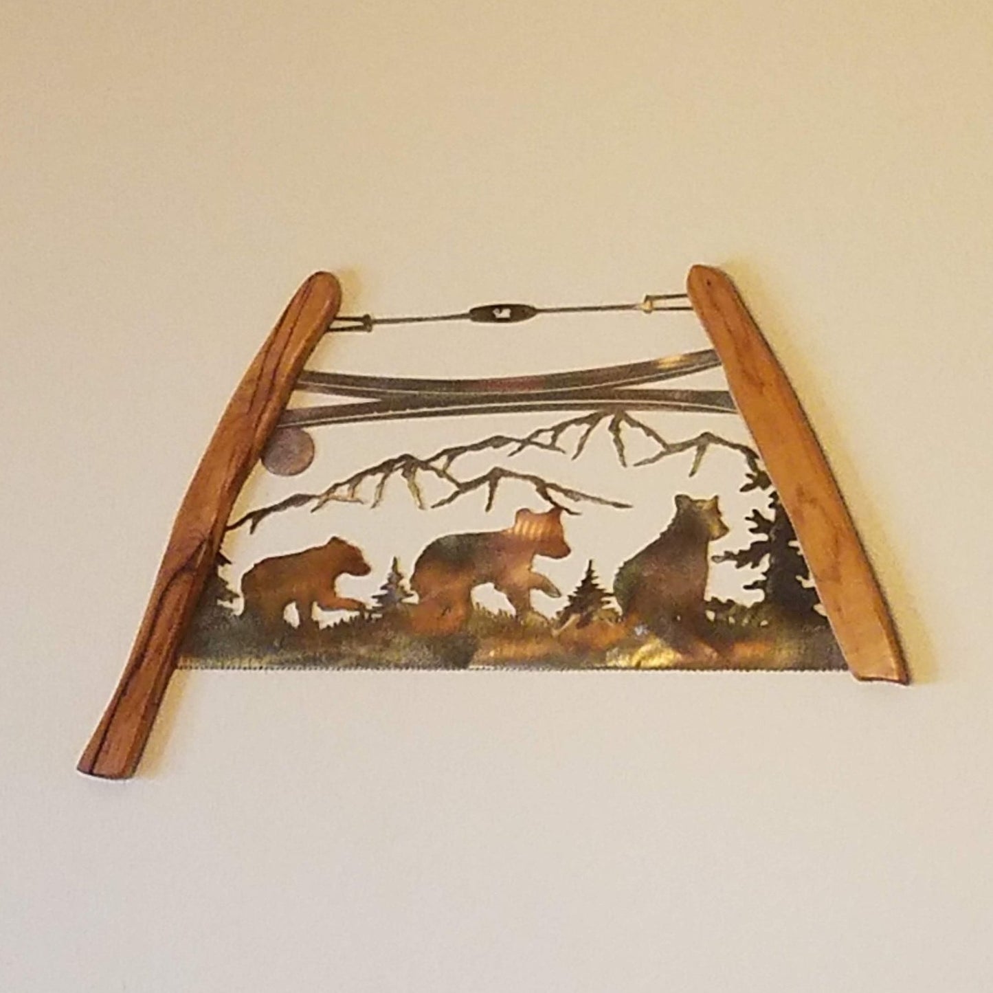 Bear Cubs Bow Saw made from 18-gauge sheet metal. Measures 15.5" High x 24" Width x .75" Depth. Has wood handles on both sides. Sprayed with a layer of Varathane.