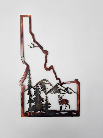 Metallic Idaho state silhouette wall art featuring a mountain and deer landscape scene, shown against a plain white background.