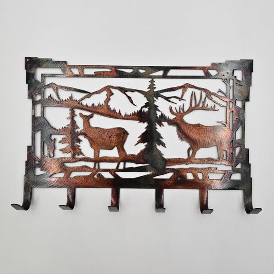 Southwest Style Rustic Elk Key Rack features a male and female elk in a mountain scene background. Measures 8" Wide x  5.5" High. Has 6 hooks for keys. Hangs via two nails not included.  Available in four colors; Colored-Rustic, Black, Hammer Tone, Bare Metal. This is the colored version. Sprayed with a thick layer of Varathane. Gift Wrapping available at checkout.